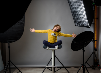 child sitting on a chair doing an extended hand pose