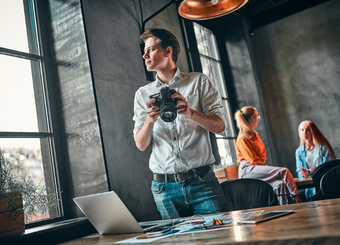 Photographer standing, looking outside of the office