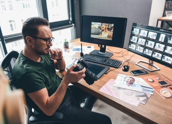 photographer looking at a camera while editing a photo of a dog
