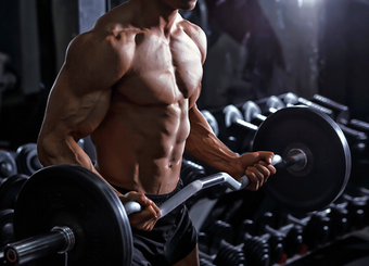 Cropped image of a male bodybuilder lifting a heavy barbell