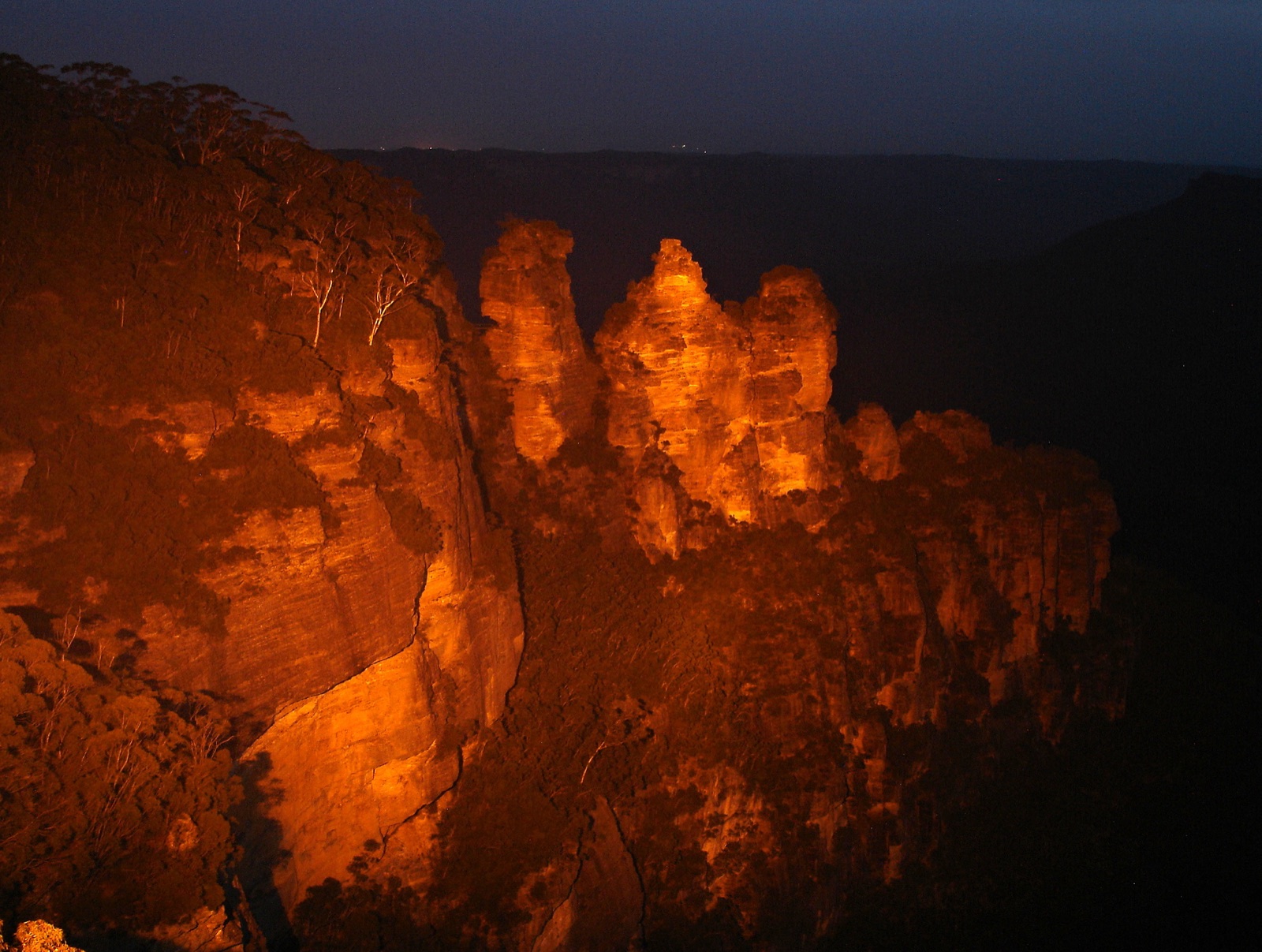 The Three Sisters sandstone rock formation rising from the eucalyptus haze of the Blue Mountains