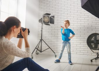 A little girl doing poses during a photoshoot