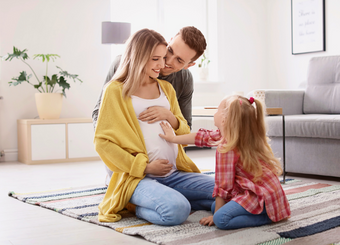 Family sitting on a mat during a maternity photoshoot