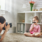 Little girl holding a mustache cut out during a photography session