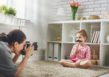 Little girl holding a mustache cut out during a photography session