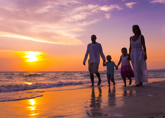 Family walking at the beach during sunset